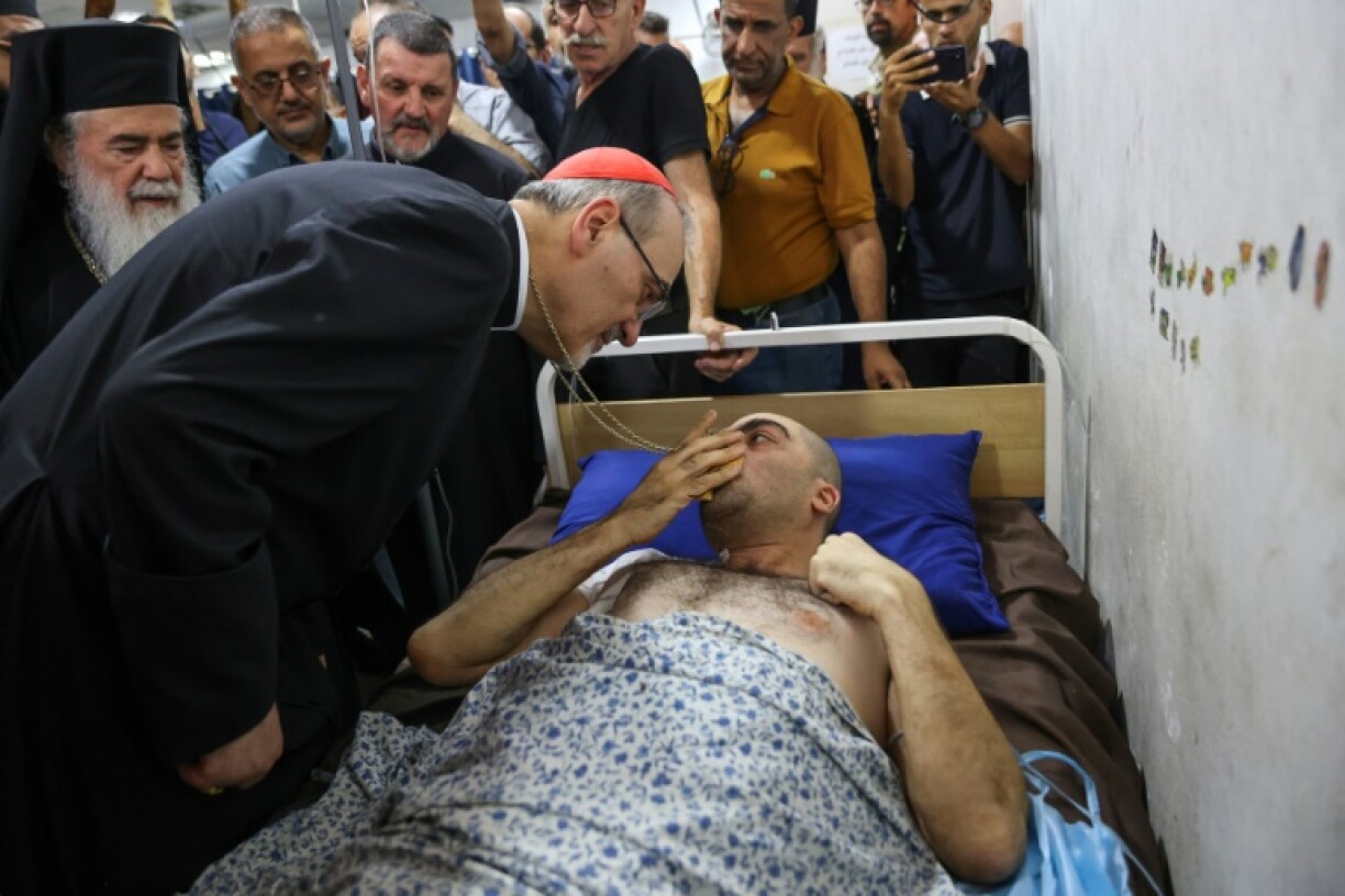 The Cardinal of Jerusalem, Pierbattista Pizzaballa, speaks to a victim of Israeli strikes during a visit to Gaza