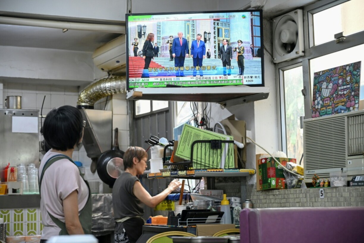 Un écran dans un restaurant de Hong Kong diffuse en direct la visite de Donald Trump en Chine, le 14 mai 2026