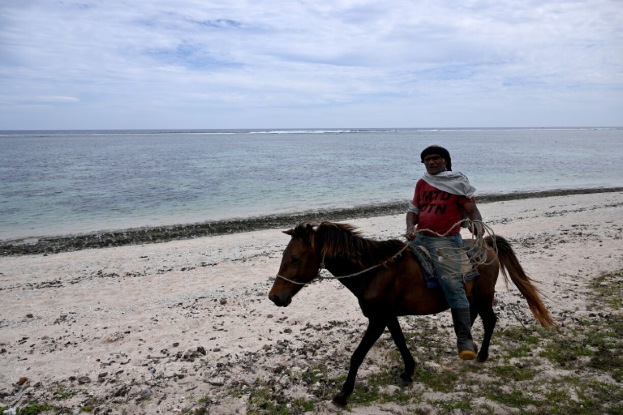 This picture taken on October 5, 2026, shows a villager riding a horse along the beach in the Naidiri Marine Biodiversity Park, a marine protected area about 52 kilometres from Nadi. Climate change is threatening the livelihoods of coastal communities in Fiji, with coral bleaching and habitat loss contributing to dwindling fish stocks.