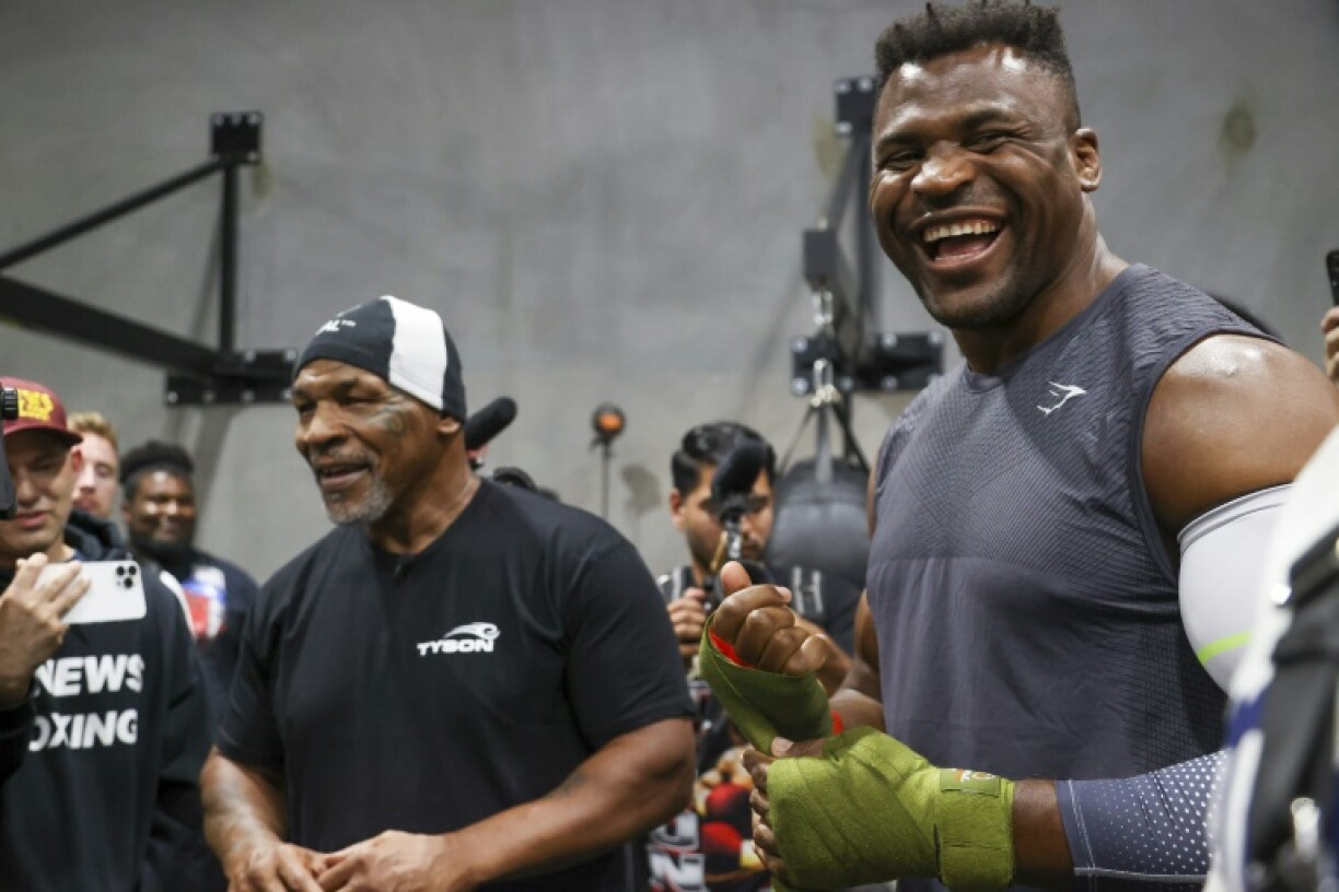 L'ex-boxeur américain Mike Tyson (g) et la star du MMA et boxeur franco-camerounais Francis Ngannou rient au gymnase de Ngannou à Las Vegas, le 26 septembre 2023