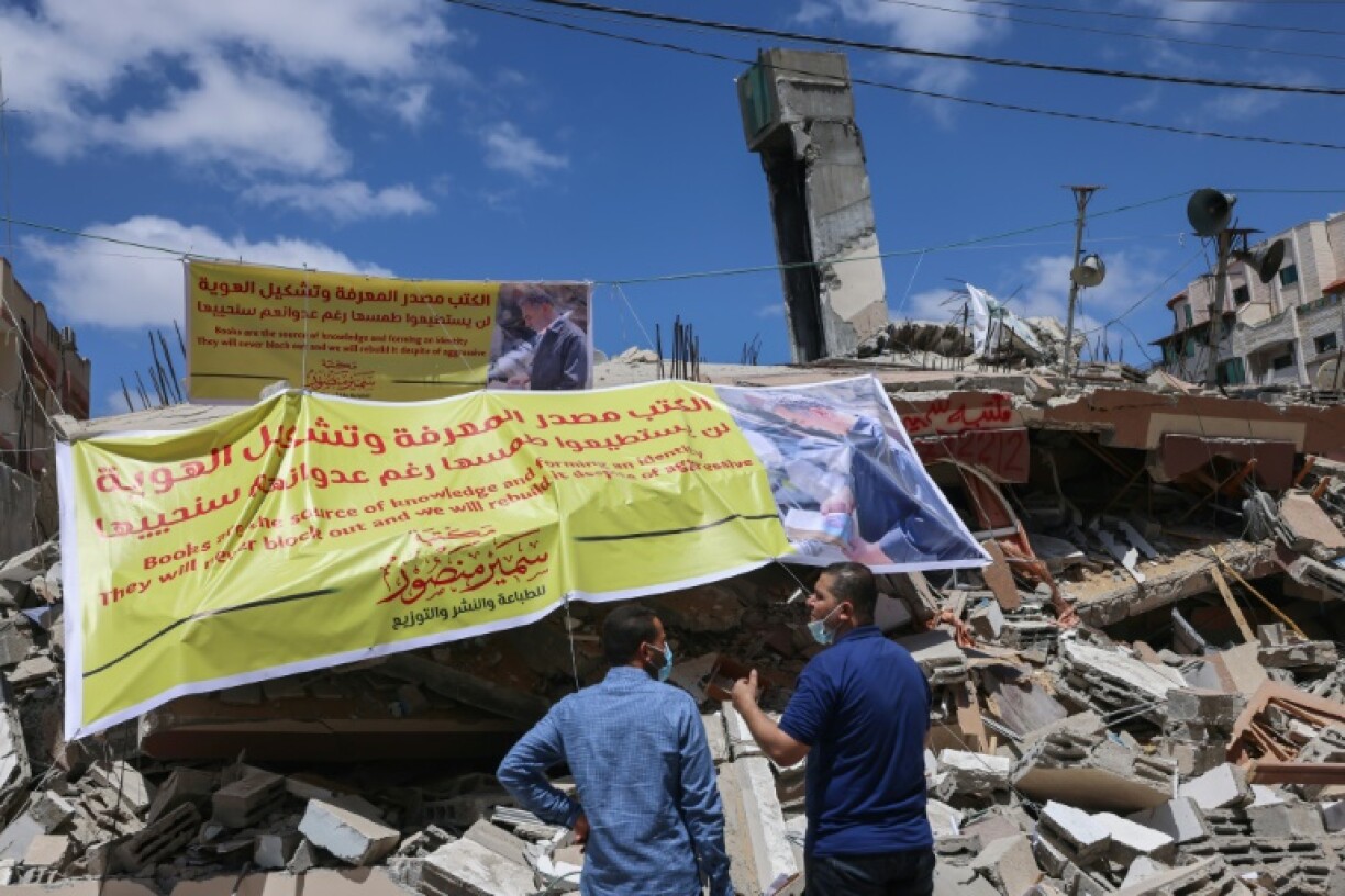 Des Palestiniens devant les ruines de la librairie al-Mansour détruite par une frappe aérienne israélienne, le 22 mai 2021 à Gaza