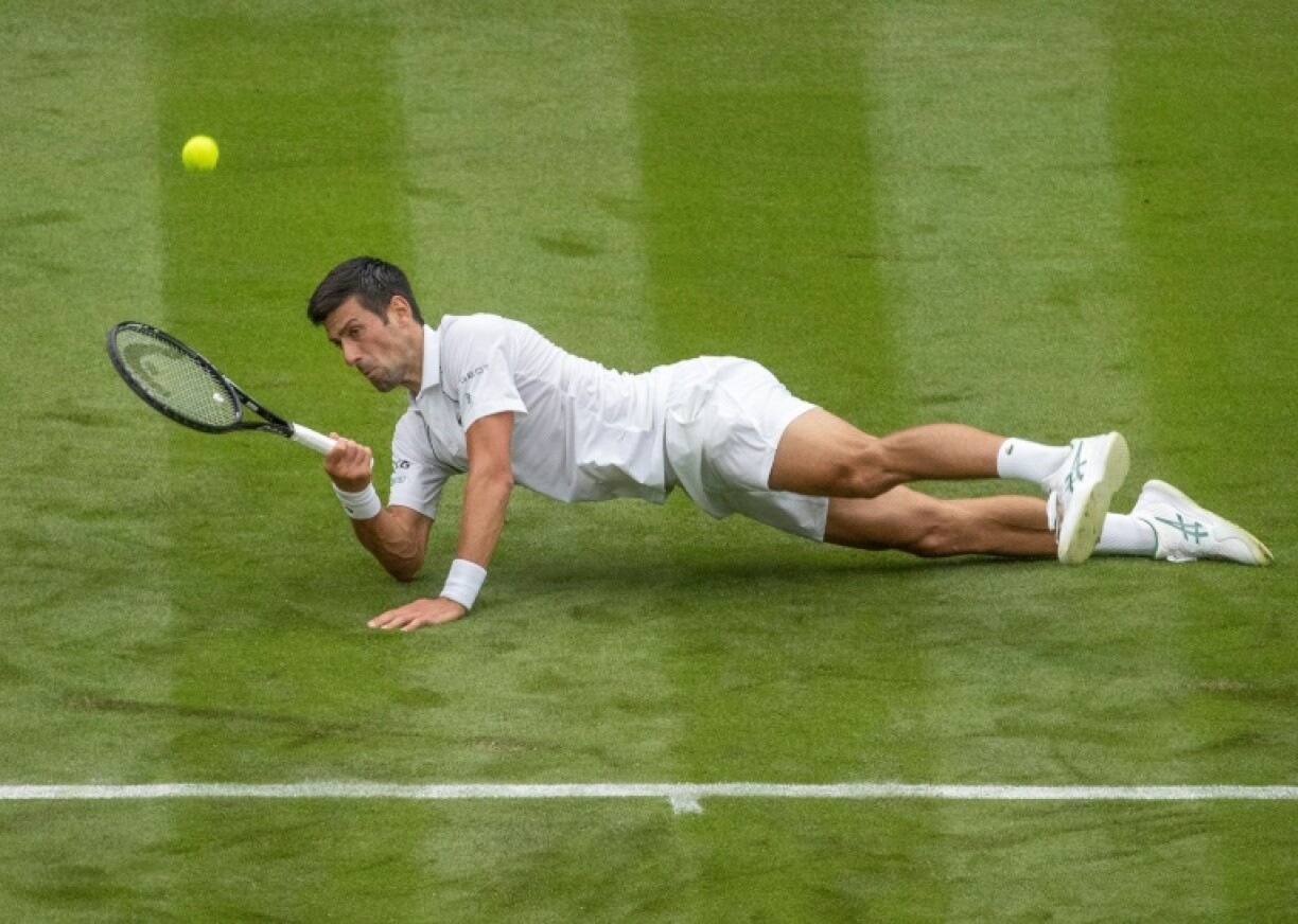 Le Serbe Novak Djokovic glisse lors de son match du 1er tour contre le Britannique Jack Draper, le 28 juin 2021 au tournoi de Wimbledon à Londres