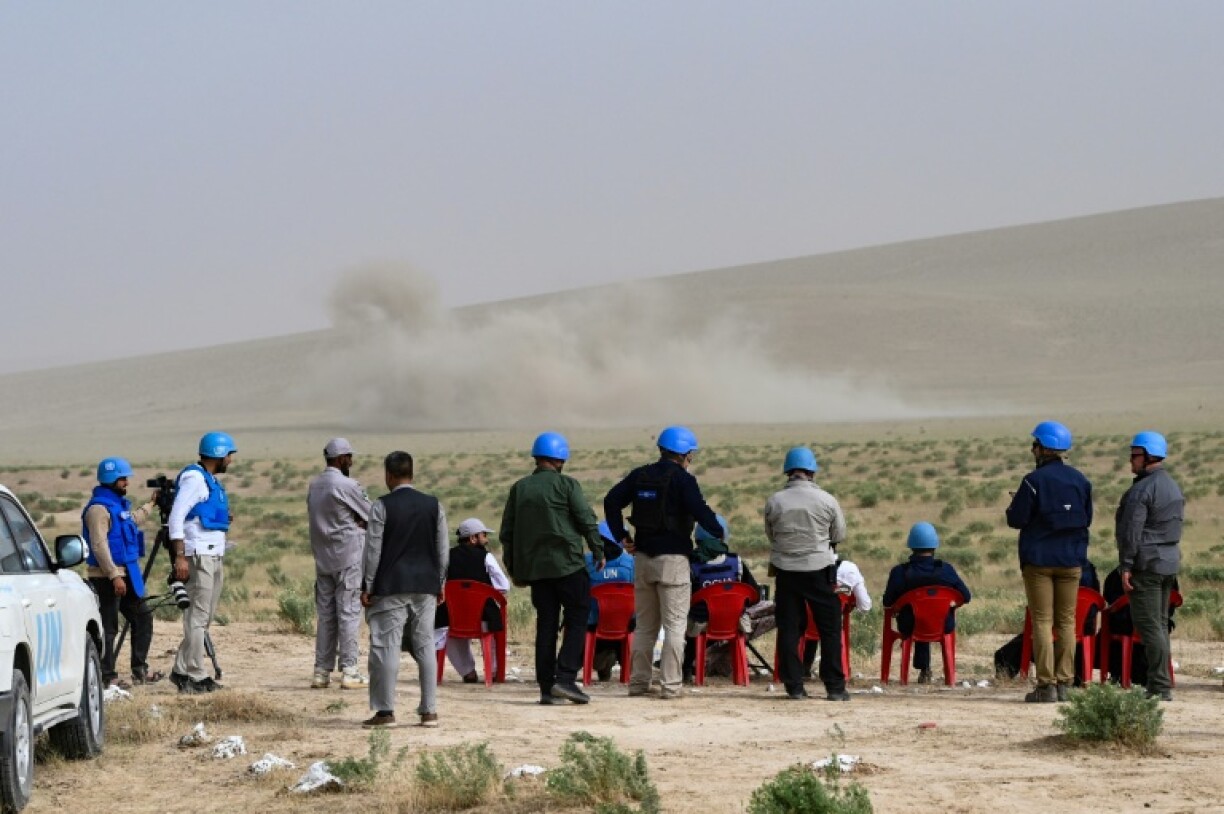 Tom Fletcher (5L) observes as Afghan deminers detonate a mine during a mine clearance demonstration