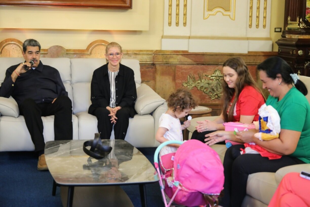 Handout picture released by Venezuela's Presidency showing Venezuela's President Nicolas Maduro (L) and First Lady Cilia Flores with Yorely Bernal (2nd R) and her daughter Maikelys Espinoza after the girl's return to Venezuela, after a period of separation from her deported parents