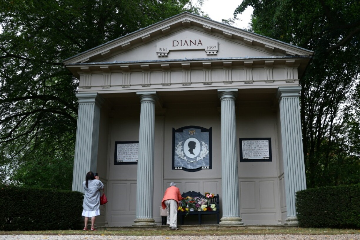 Des personnes déposent des fleurs devant un mémorial dédié à la princesse Diana, dans le parc d'Althorp House, près de Northampton, le 31 août 2026, à l'occasion du 29e anniversaire de sa mort