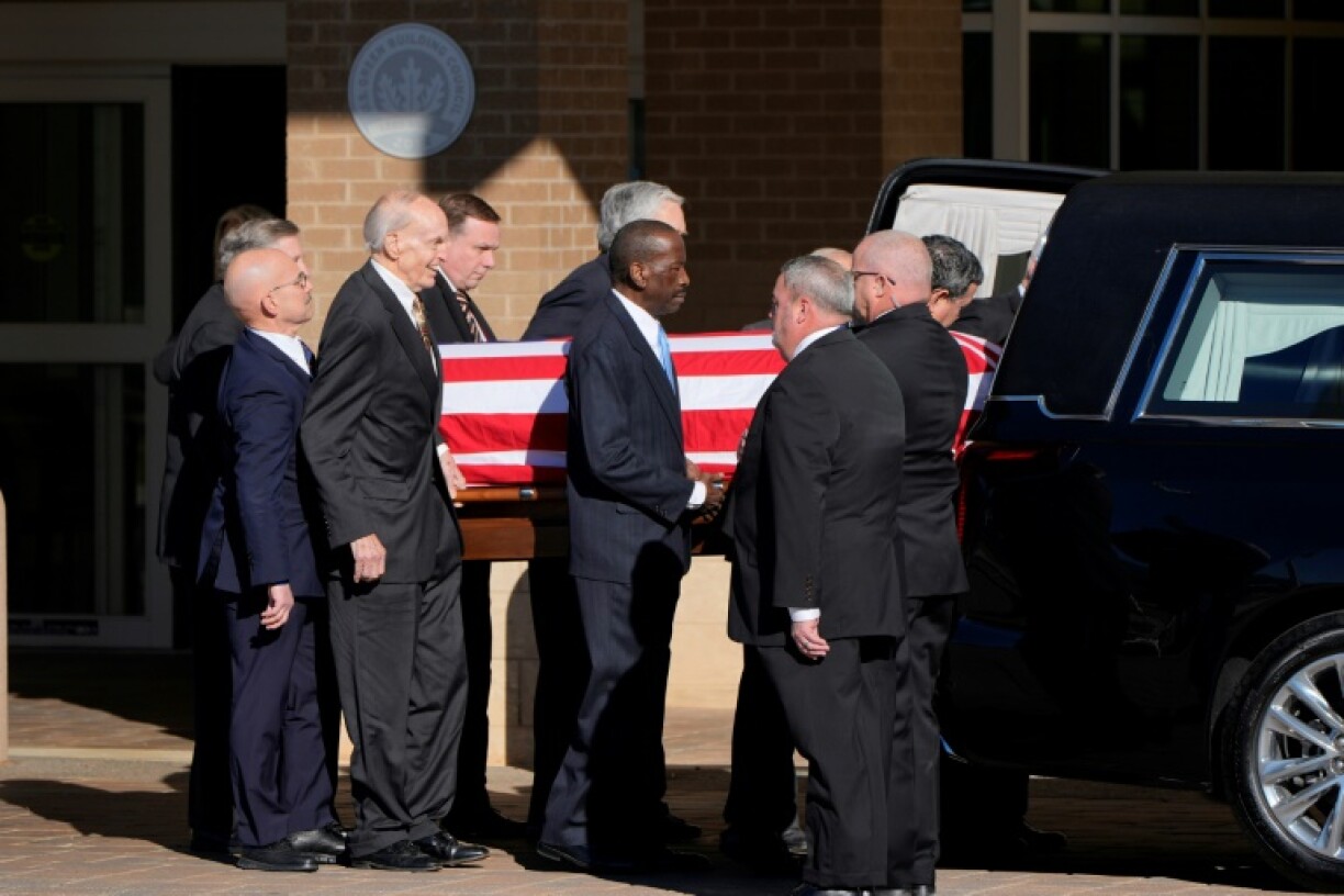Former and current US Secret Service agents assigned to the Carter detail walk with the hearse carrying the flag-draped casket of former US President Jimmy Carter in Americus, Georgia, on January 4, 2025