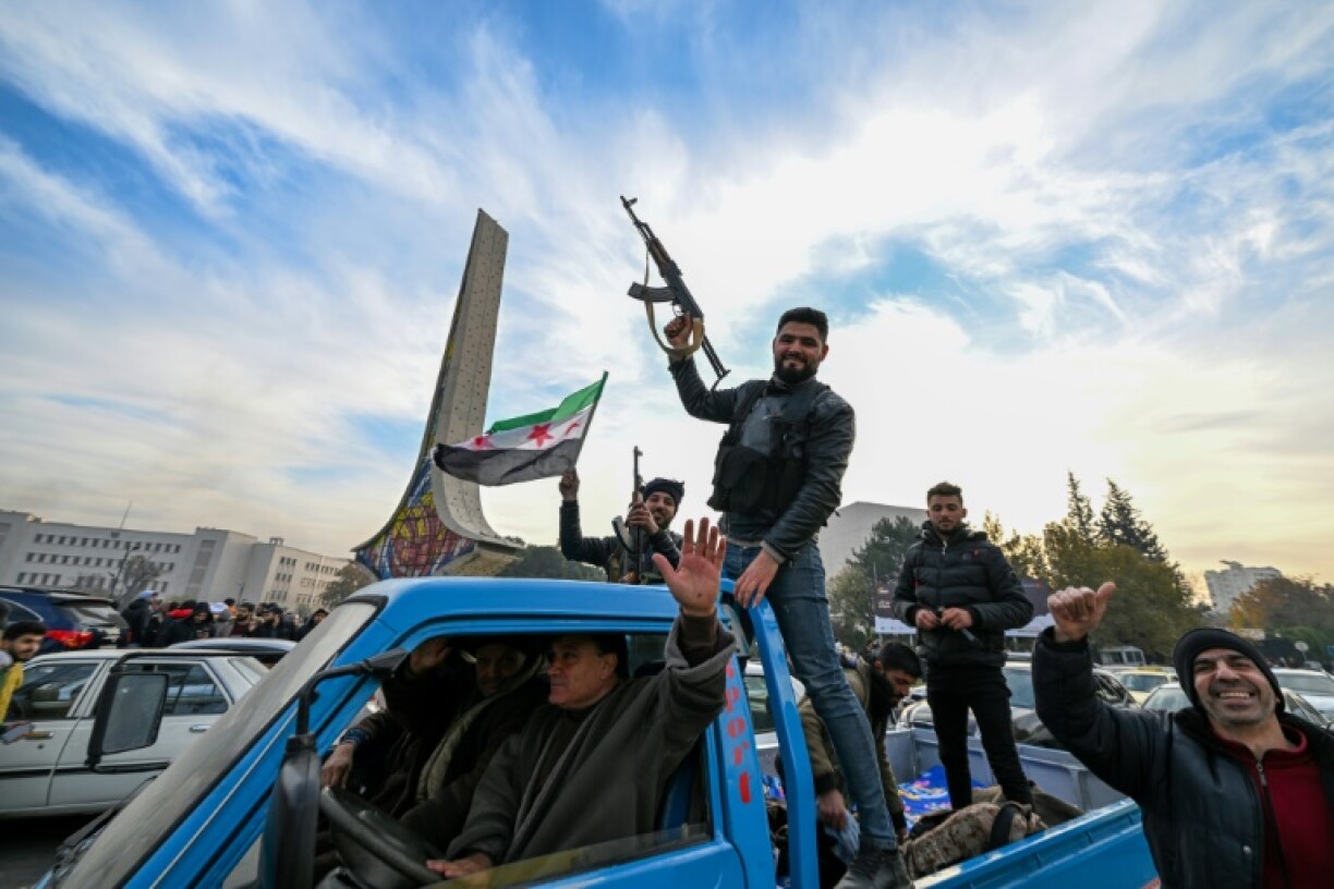 Anti-government fighters cheer from the back of a car at Umayyad Square in Damascus