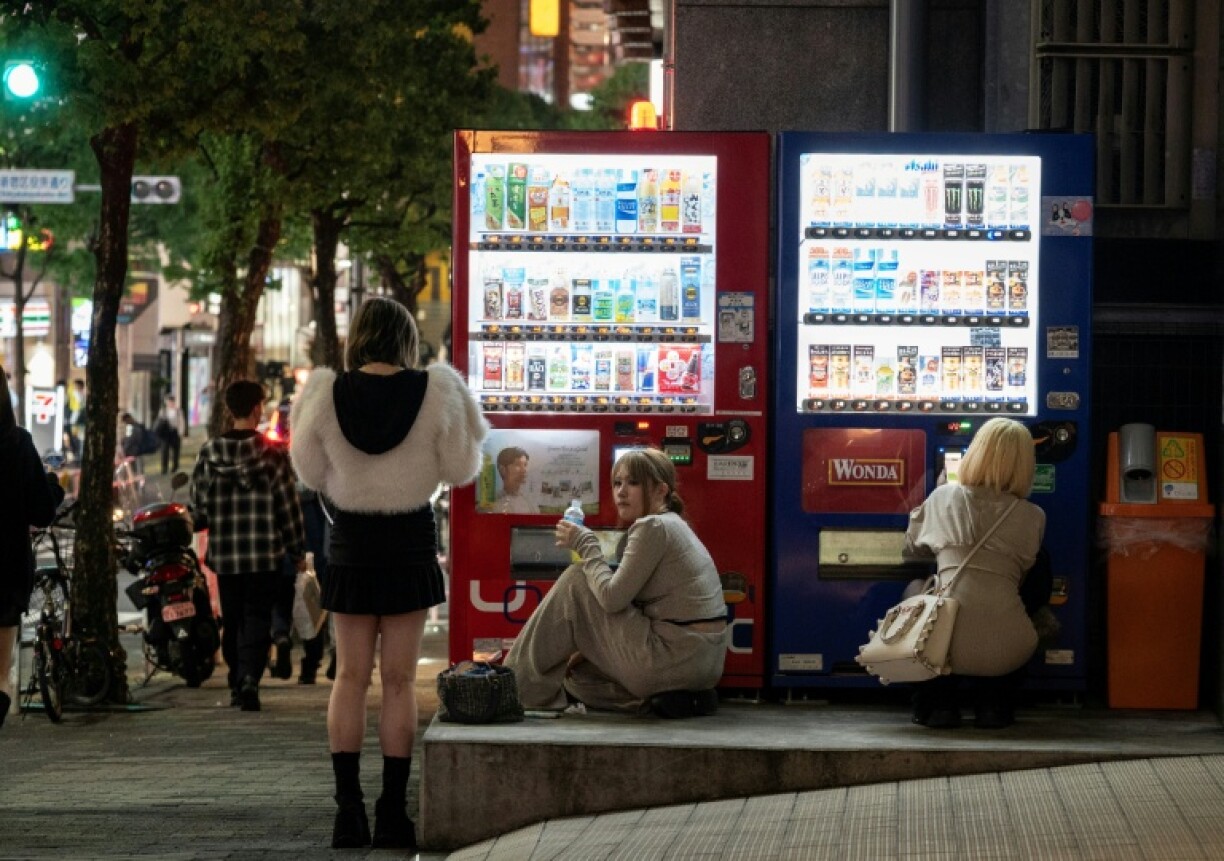 Des femmes se procurent des boissons auprès de distributeurs automatiques, le 13 avril 2026 à Tokyo