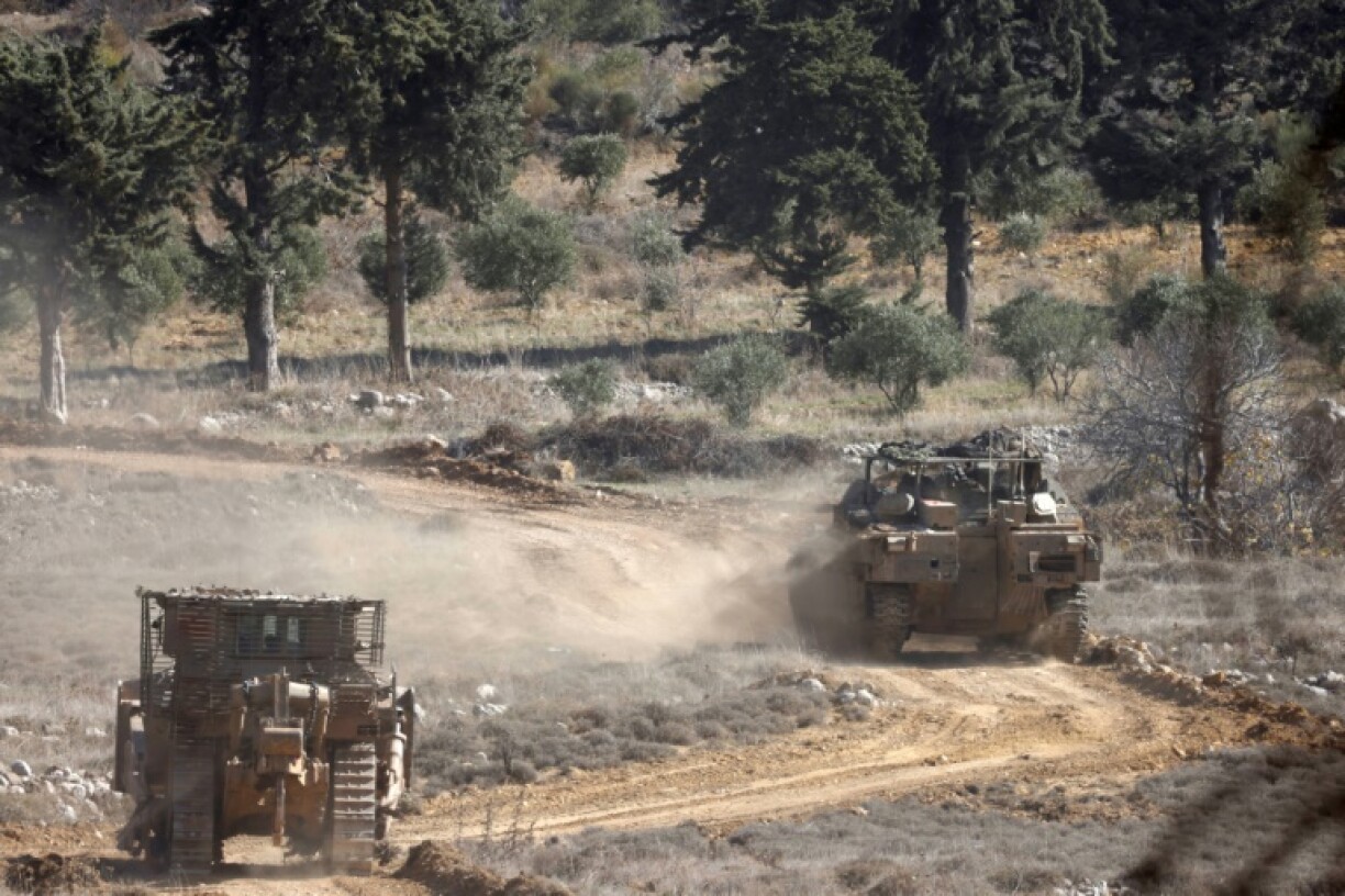 Israeli army tanks drive in the UN-patrolled buffer zone, which separates Israeli and Syrian forces on the Golan Heights, near the Druze village of Majdal Shams