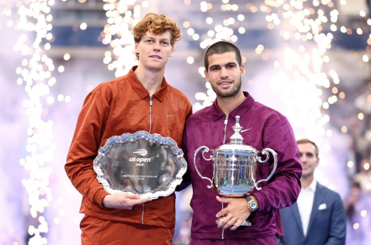 L'Espagnol Carlos Alcaraz et l'Italien Jannik Sinner posent avec leurs trophées après qu'Alcaraz a remporté la finale de l'US Open, à New York, le 7 septembre 2025