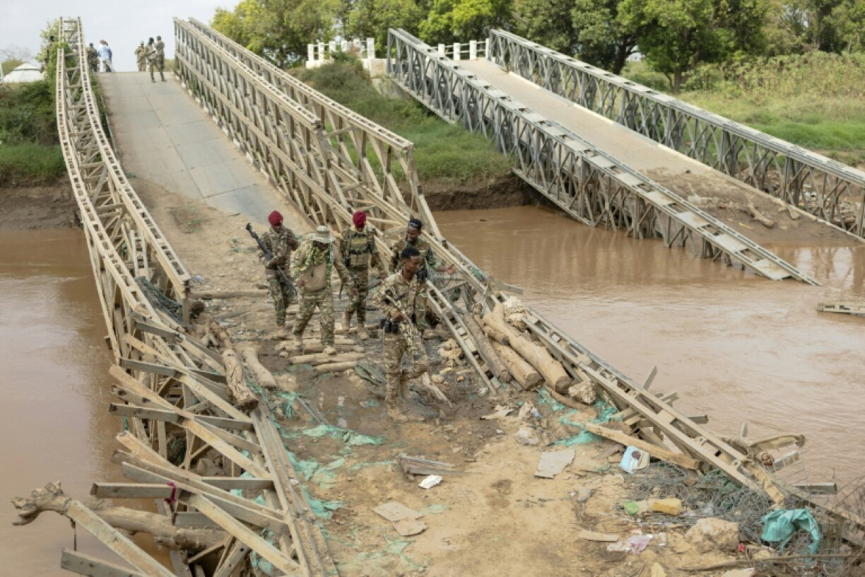 Des soldats de l'armée nationale somalienne traversent le 11 novembre 2025, un pont détruit au-dessus de la rivière Shabelle, en Somalie