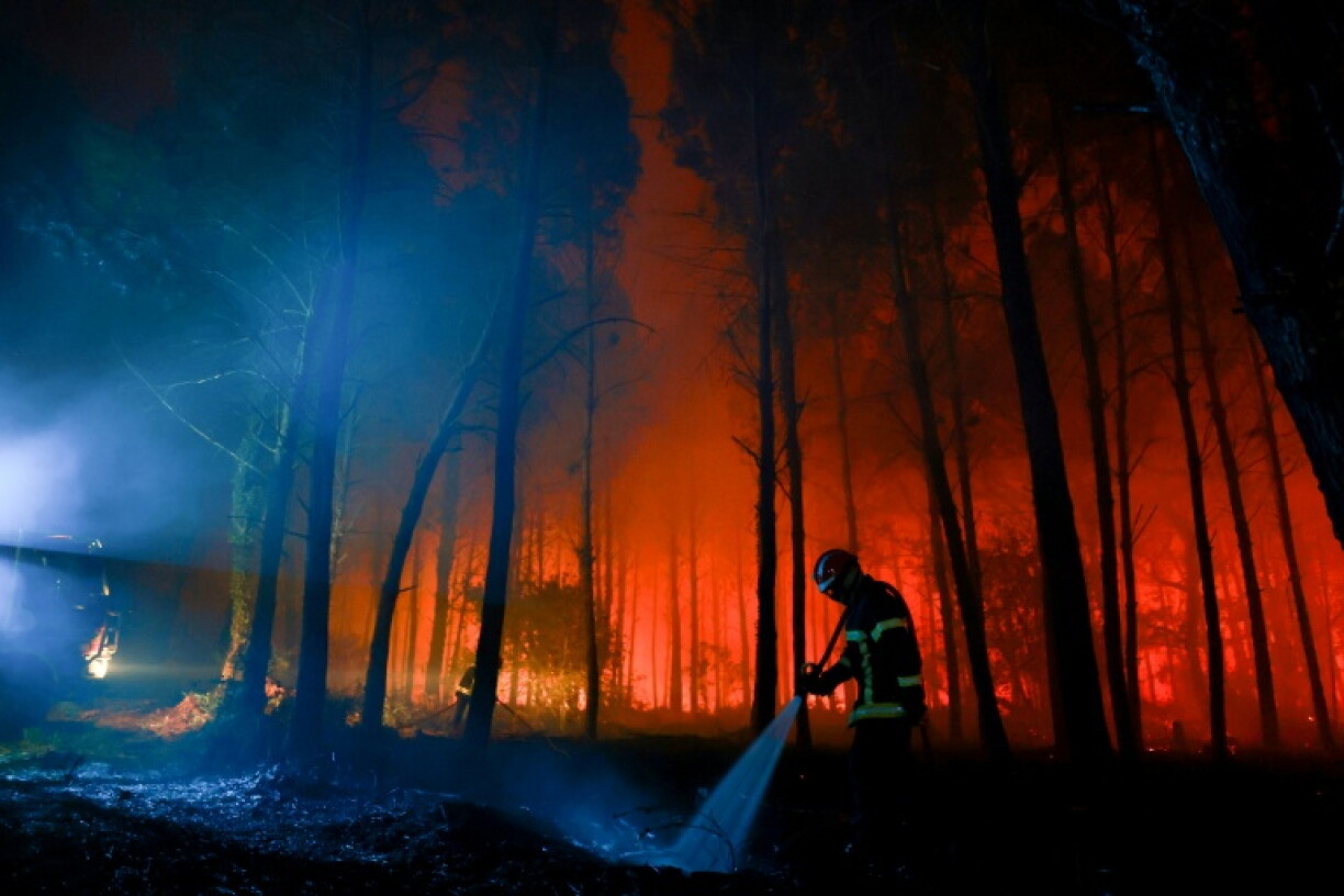 Un pompier éteint les débris d'un incendie de forêt à Luglon, dans les Landes, le 14 août 2026