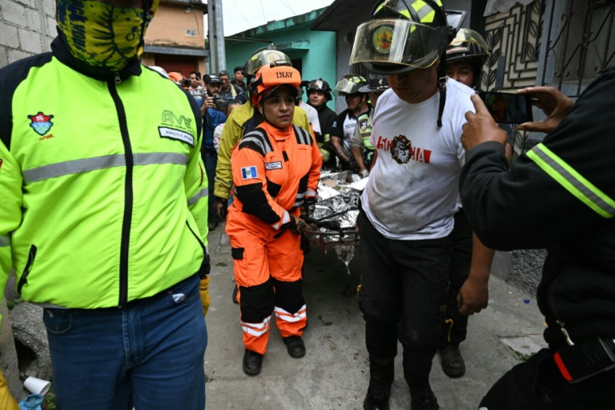 Rescuers carry the body of one of the victims of a bus crash in Guatemala