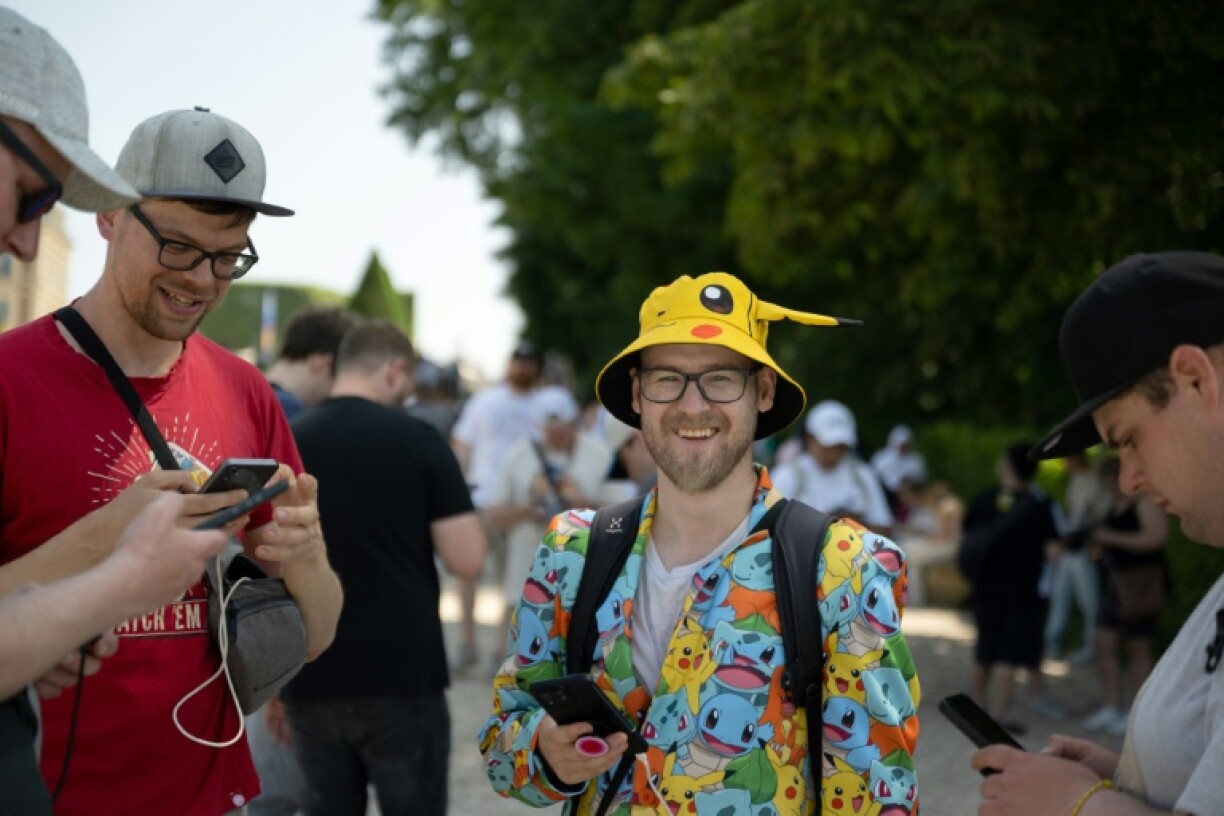 Des fans jouent à Pokémon Go sur leurs smartphones, le jour de l'ouverture du Pokémon Go Fest 2025, au Parc de Sceaux, au sud de Paris, le 13 juin 2025