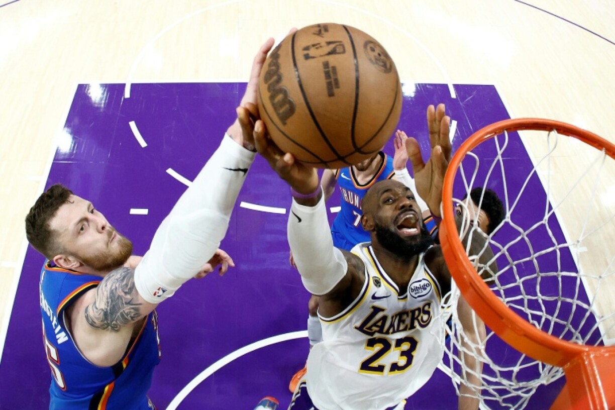 LeBron James (c.), l'ailier fort des Lakers de Los Angeles, monte au panier face à Isaiah Hartenstein (g.), le pivot du Thunder d'Oklahoma City, lors du troisième match du deuxième tour des play-offs de la Conférence Ouest de la NBA, à Los Angeles, le 9 mai 2026