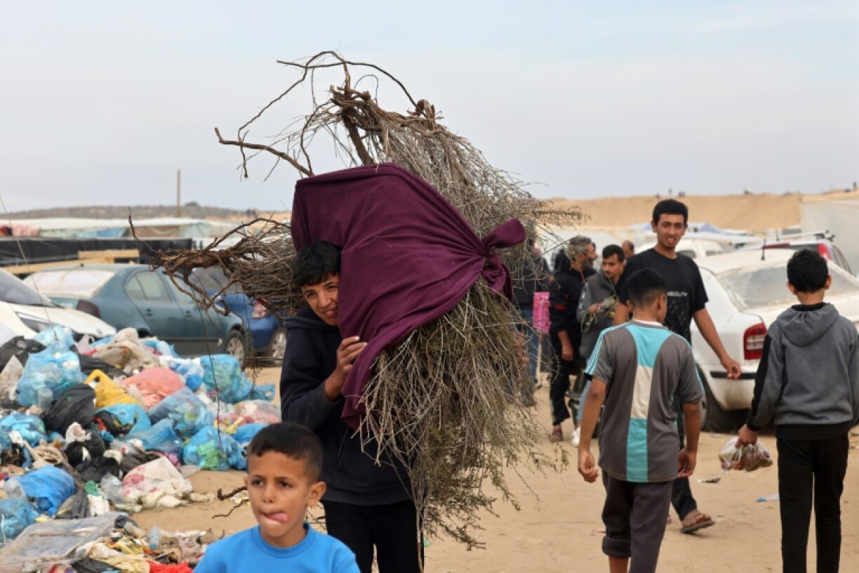 Un garçon porte du bois pour le chauffage et la cuisine à Rafah, dans le sud de la bande de Gaza, le 7 décembre 2023, où une partie de la population du camp de Khan Younès s'est réfugiée pour fuir les combats.