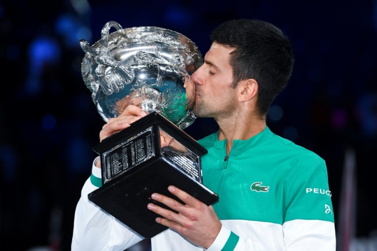 Le Serbe Novak Djokovic embrasse le trophée de l'Open d'Australie, après sa victoire en finale, le 21 février 2021 à Melbourne