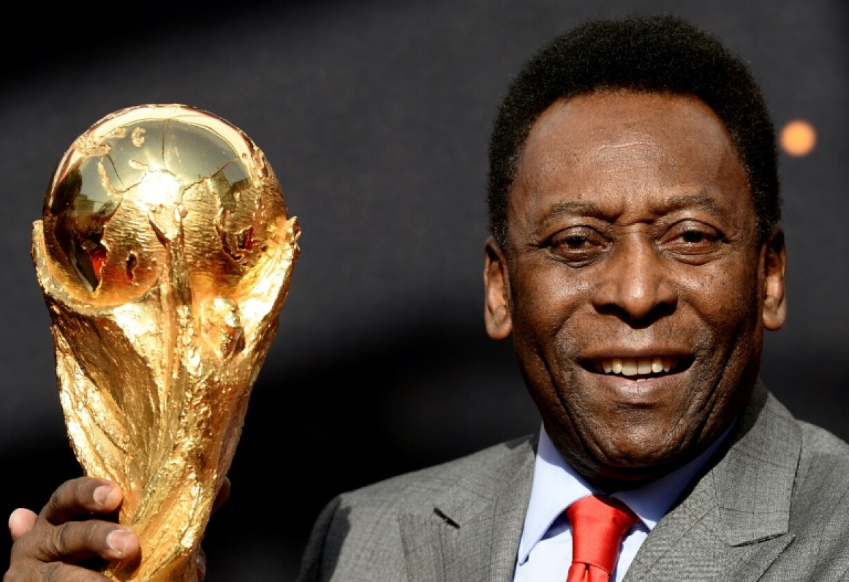 L'ex-joueur brésilien Pelé pose avec le trophée de la Coupe du monde, à Paris, le 9 mars 2014