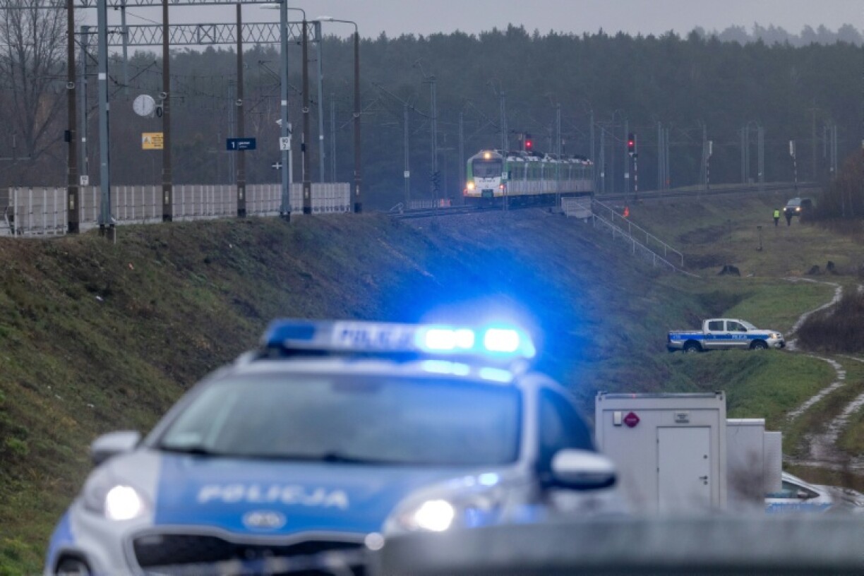 Police cars are seen close to a railway line damaged in an explosion in Mika, central Poland, that has been branded 'sabotage' by the government