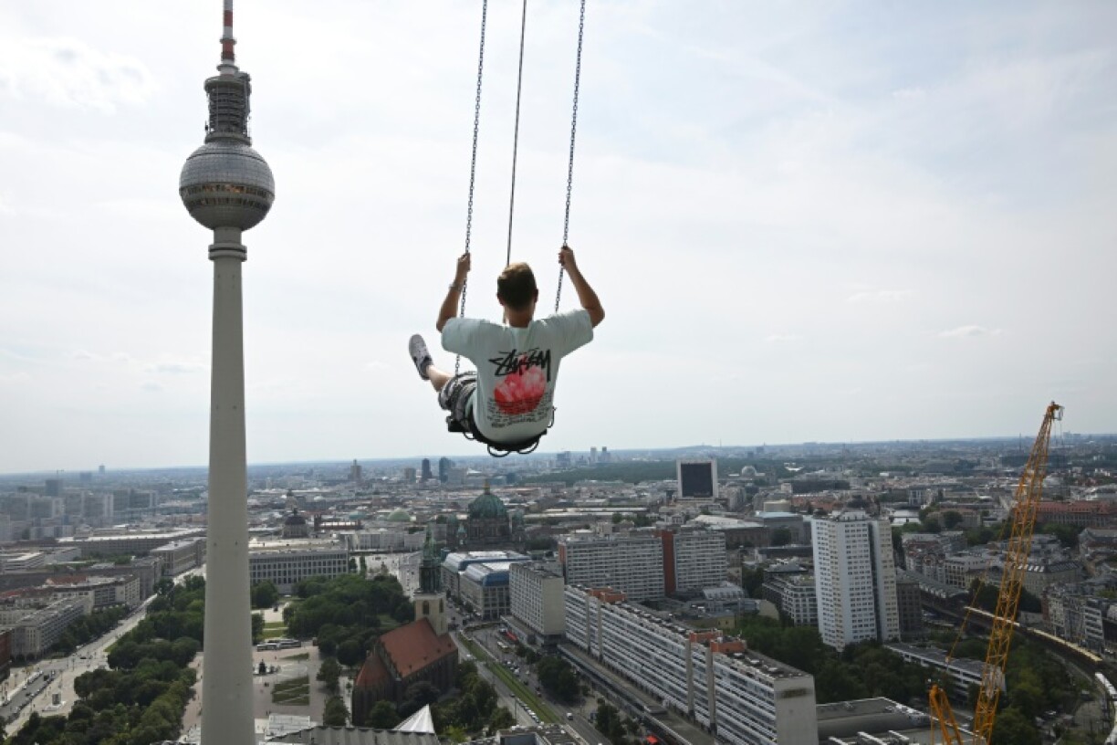 Pascal Vent, 36 ans, se balance à 120 mètres au dessus de Berlin sur la plus haute balançoire d'Europe à l'Alexanderplatz, le 31 juillet 2024
