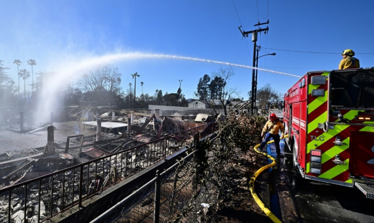 Firefighters water down smoky embers at the fire ravaged Sahag Mesrob Armenian Christian School in Altadena, California