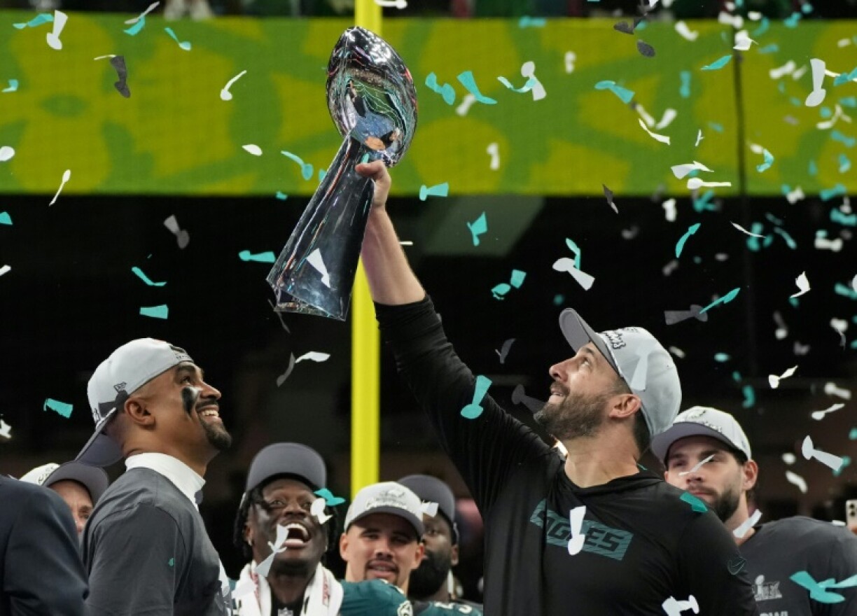 Philadelphia Eagles coach Nick Sirianni holds the Vince Lombardi Trophy aloft as quarterback Jalen Hurts looks on after Sunday's Super Bowl triumph