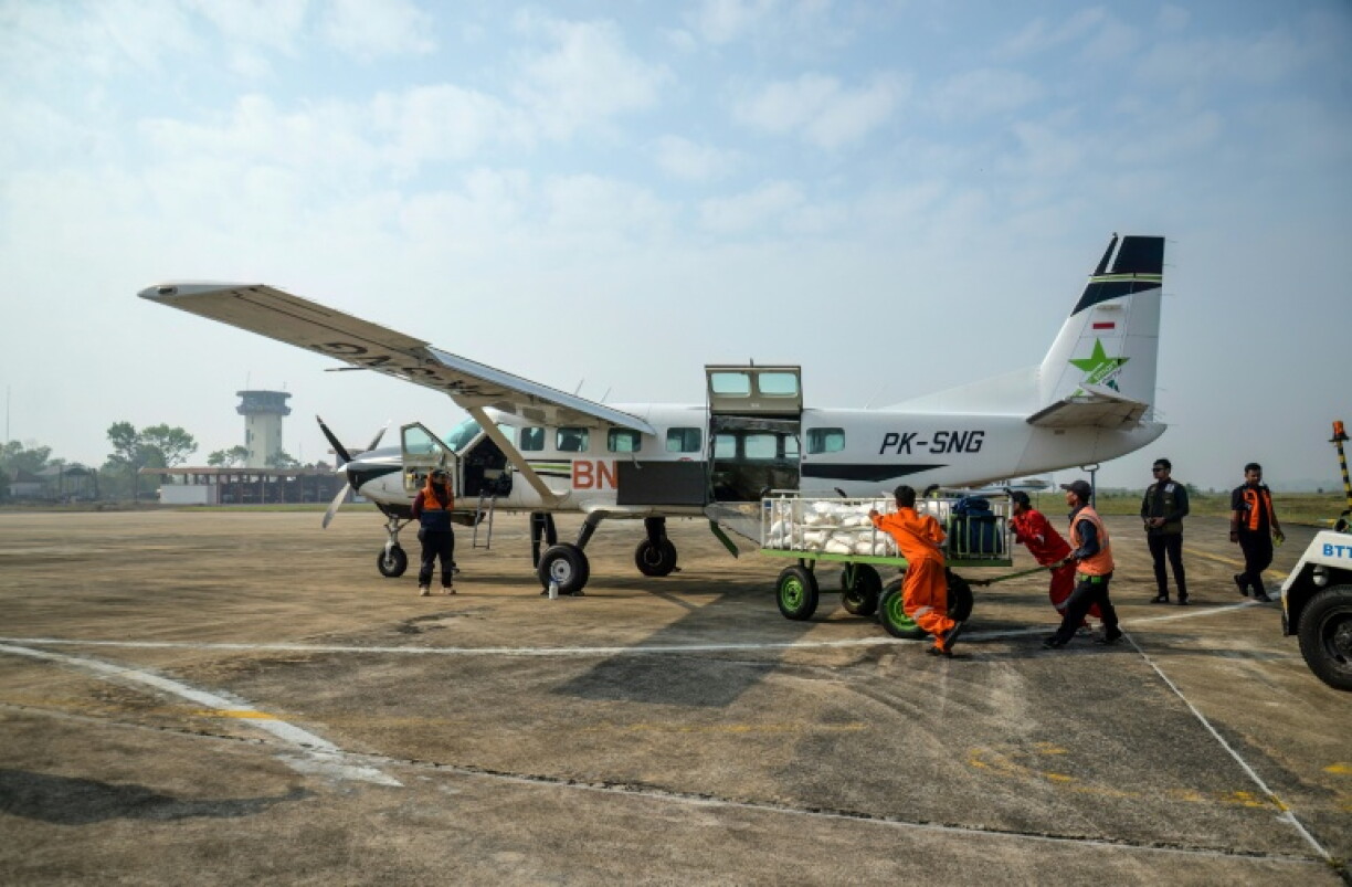 Des agents de l'Agence nationale de gestion des catastrophes chargent un avion avant une opération d'ensemencement des nuages à Palangkaraya, dans le Kalimantan central, province indonésienne sur l'île de Bornéo, le 2 août 2026