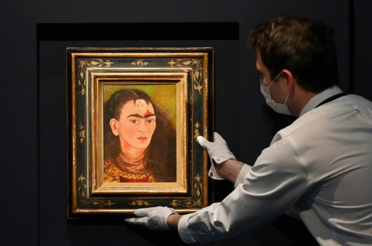 Un employé de Sotheby's ajuste un autoportrait de Frida Kahlo,