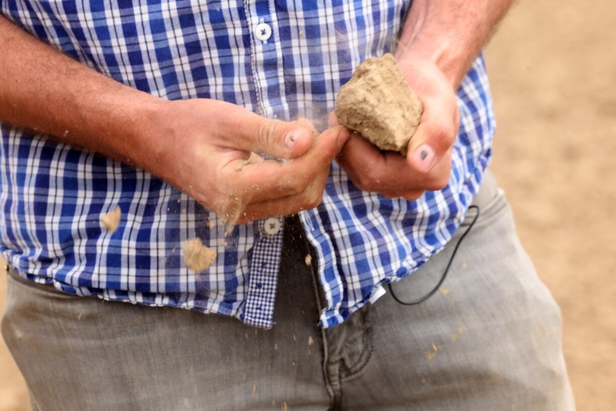 Adrien Mastain, maraîcher, émiette un morceau de terre sèche prélevé dans un champ qu'il devra arroser artificiellement pour cultiver ses légumes, à Carnin, dans le nord de la France.