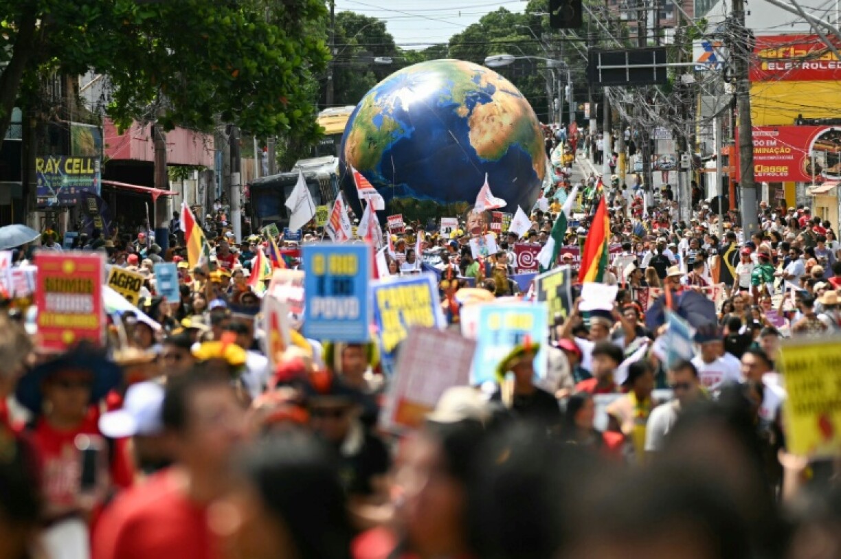 Under a baking sun, Indigenous people mixed with activists marched in a festive atmosphere in Belem