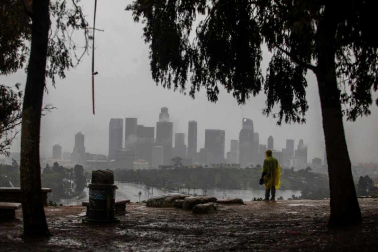 Un homme vêtu d'une cape imperméable regarde la pluie tomber sur Los Angeles, en Californie, le 24 décembre 2025
