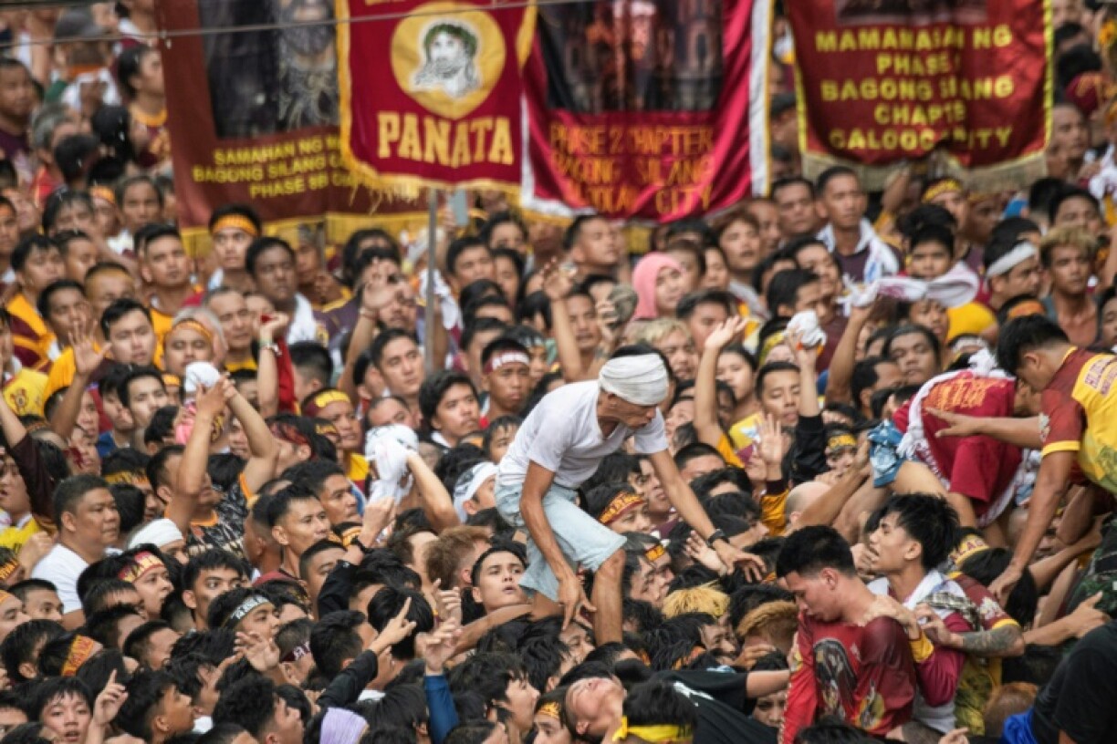A Catholic devotee scrambles to reach the centuries-old Jesus the Nazarene statue during an annual procession in the Philippine capital