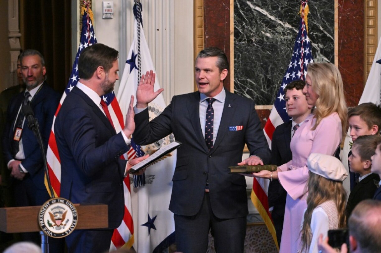 Pete Hegseth (C) -- surrounded by his wife and children -- is sworn in as the new US secretary of defense by Vice President JD Vance (L)
