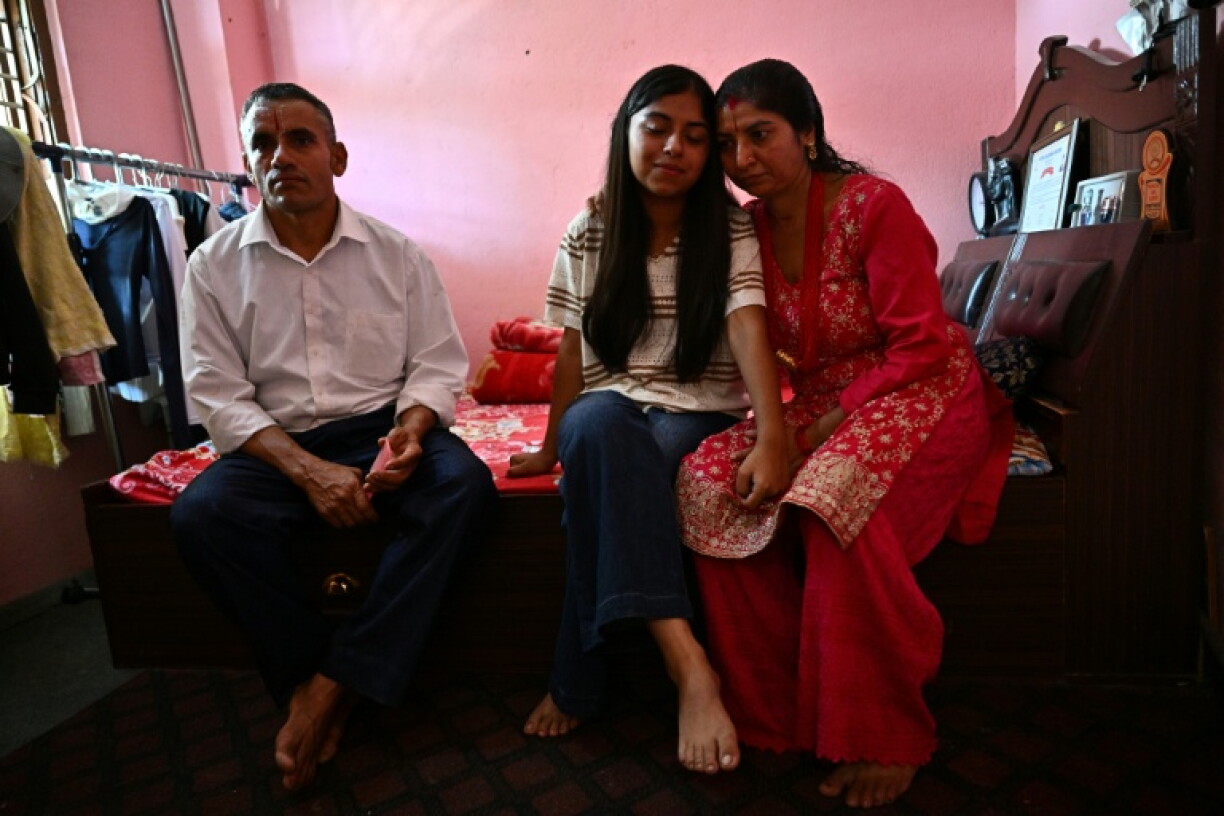 Santoshi Dotel (au centre) et ses parents, Raj Kumar Dotel (à gauche) and Durga Dotel, dans leur maison à Trishuli Bazar, Népal, le 5 septembre 2026