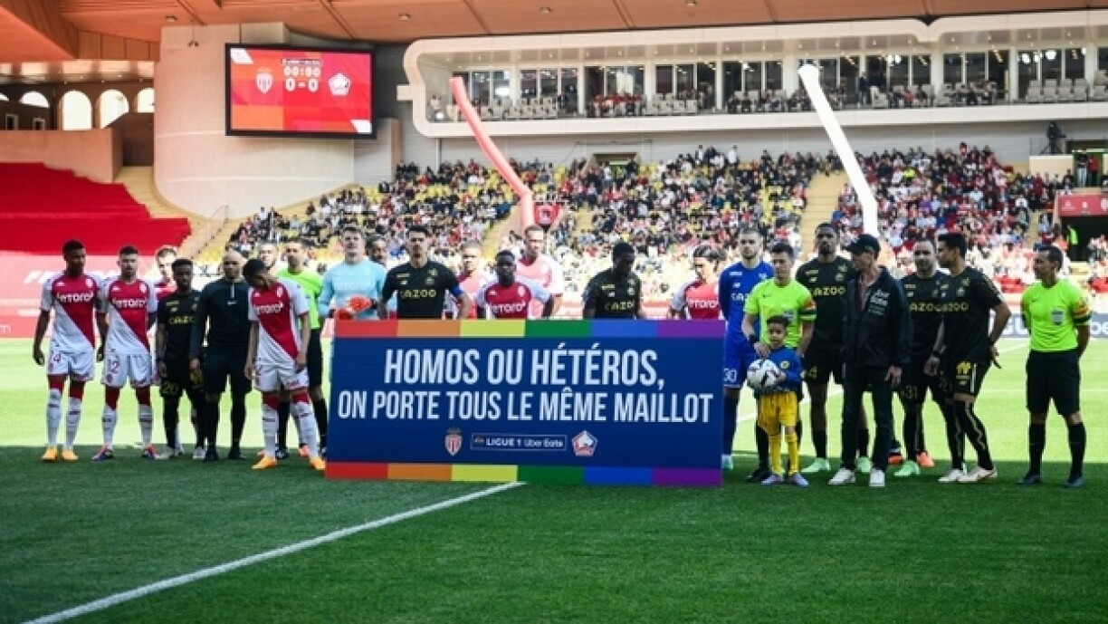 Les joueurs de Monaco et de Lille avec une pancarte de la campagne contre l'homophobie de la Ligue 1, le 14 mai 2023 à Monaco.