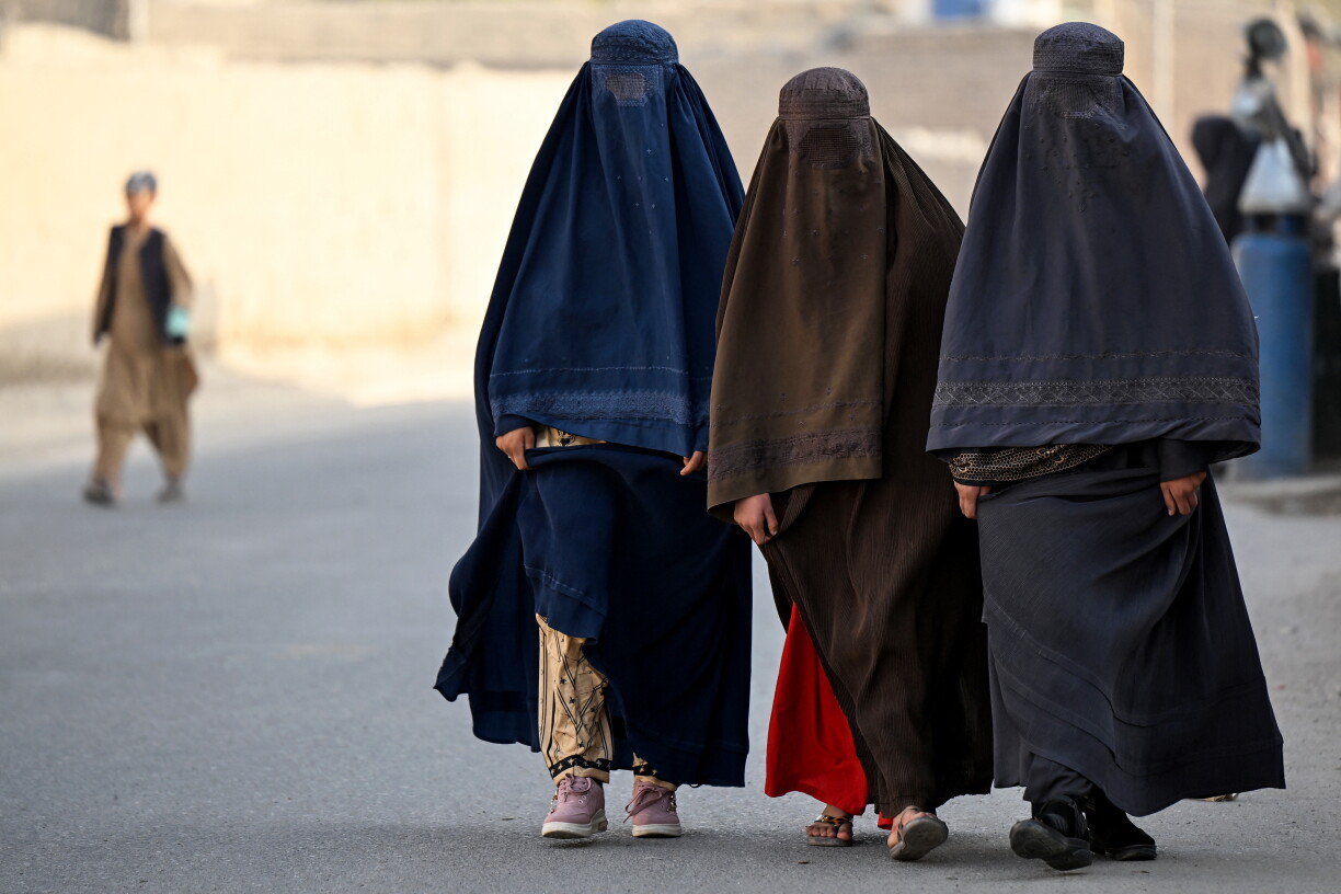 Afghan burqa-clad women walk along a street in the Dand district of Afghanistan's Kandahar province on October 5, 2026. (Photo by Sanaullah SEIAM / AFP)
