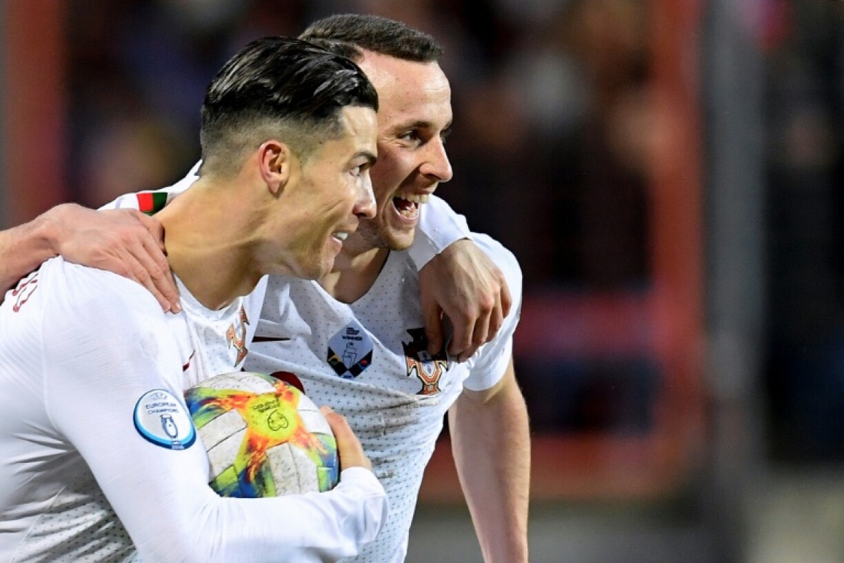 Cristiano Ronaldo (L) celebrates with Diogo Jota after scoring a goal in 2019