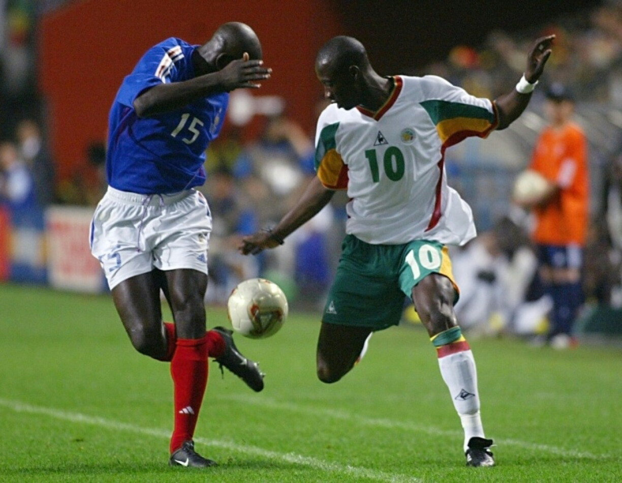 Khalilou Fadiga (à droite) à la lutte avec le défenseur français Lilian Thuram (L) le 31 mai 2002 à Séoul en ouverture de la Coupe du monde. Ce jour-là, se souvient l'ancien international sénégalais, "on a forcé le respect de ceux qui ne nous connaissaient pas".