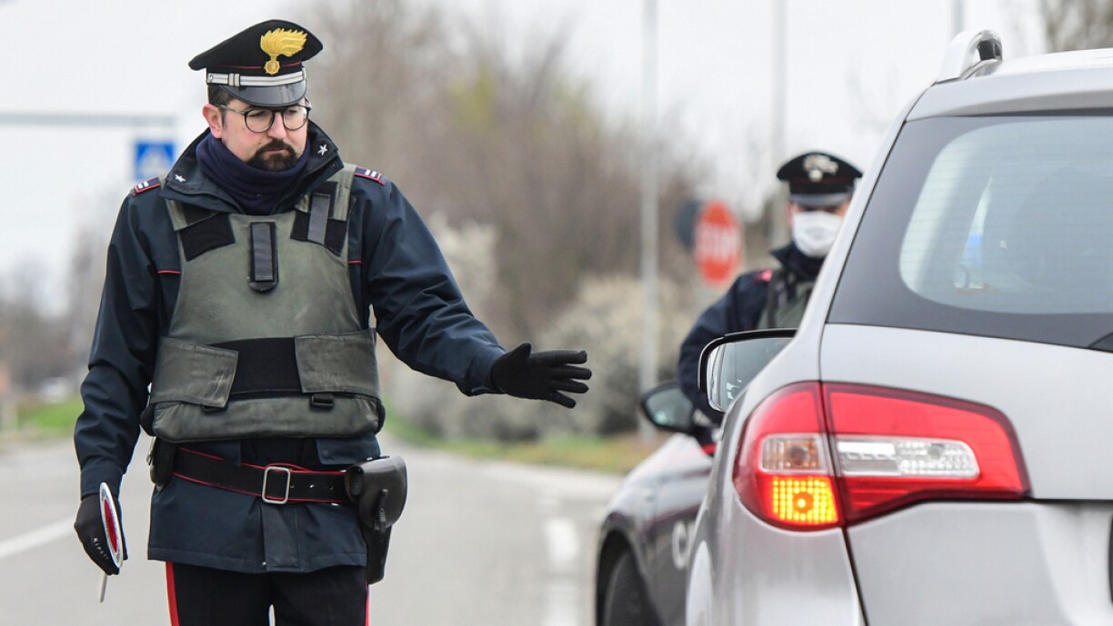 Italian Carabinieri police officers hold a road check point at the border between the quarantined provinces of Modena and Bologna on March 9, 2020 before the nation-wide lockdown.