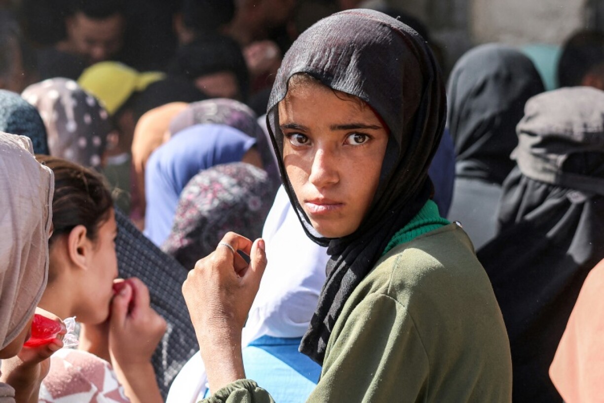 Une jeune fille attend dans une foule une distribution de pain devant une boulangerie de Khan Younès, dans le sud de la bande de Gaza, le 23 octobre 2024