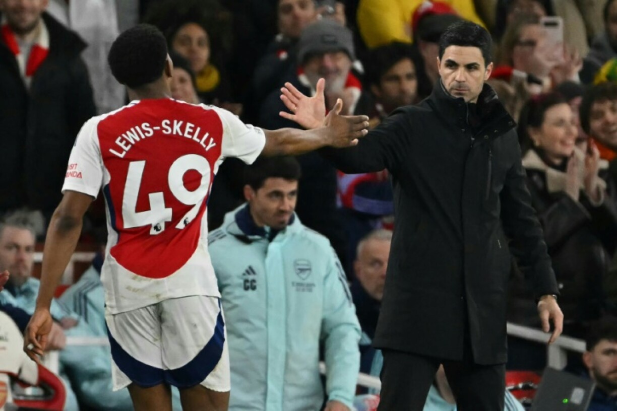 Arsenal boss Mikel Arteta (R) and defender Myles Lewis-Skelly