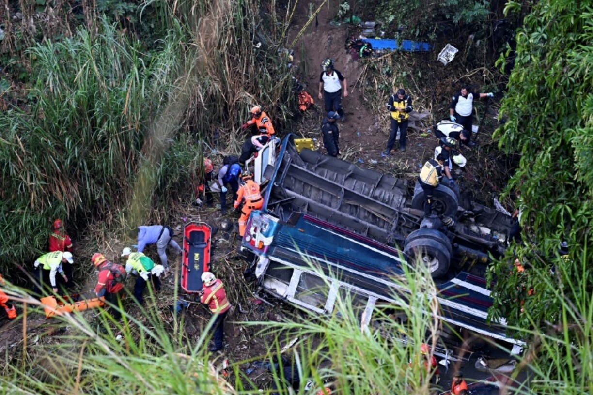 Firefighters and police work at the scene of a bus crash in Guatemala City on February 10, 2025