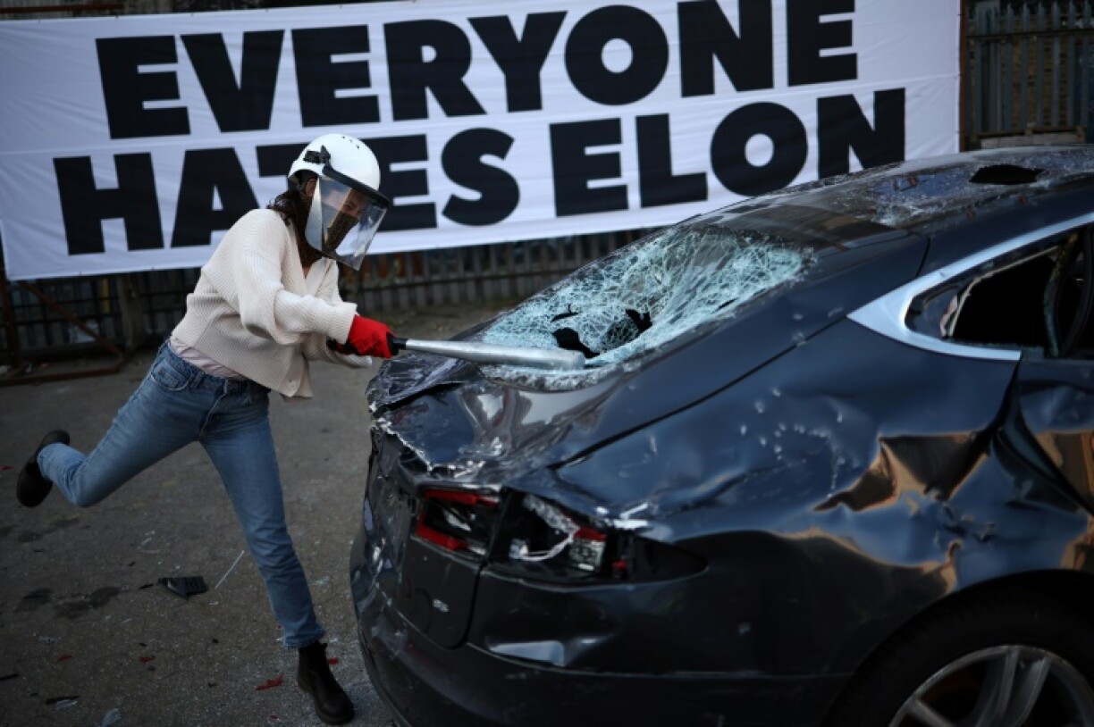 A person smashes a Tesla car during anti Elon Musk protest in London