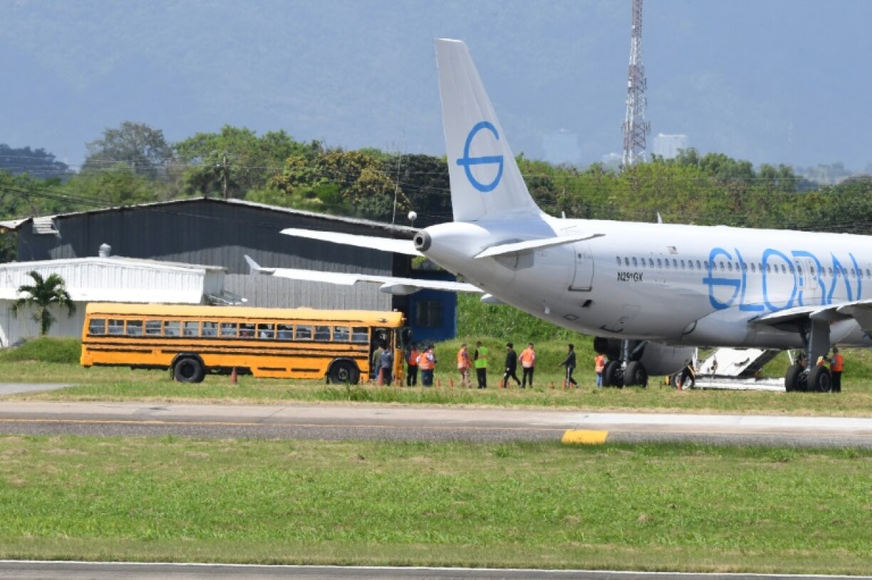 Brazilian migrants deported from the United States walk to board a bus upon arrival at the Pinto Martins International Airport