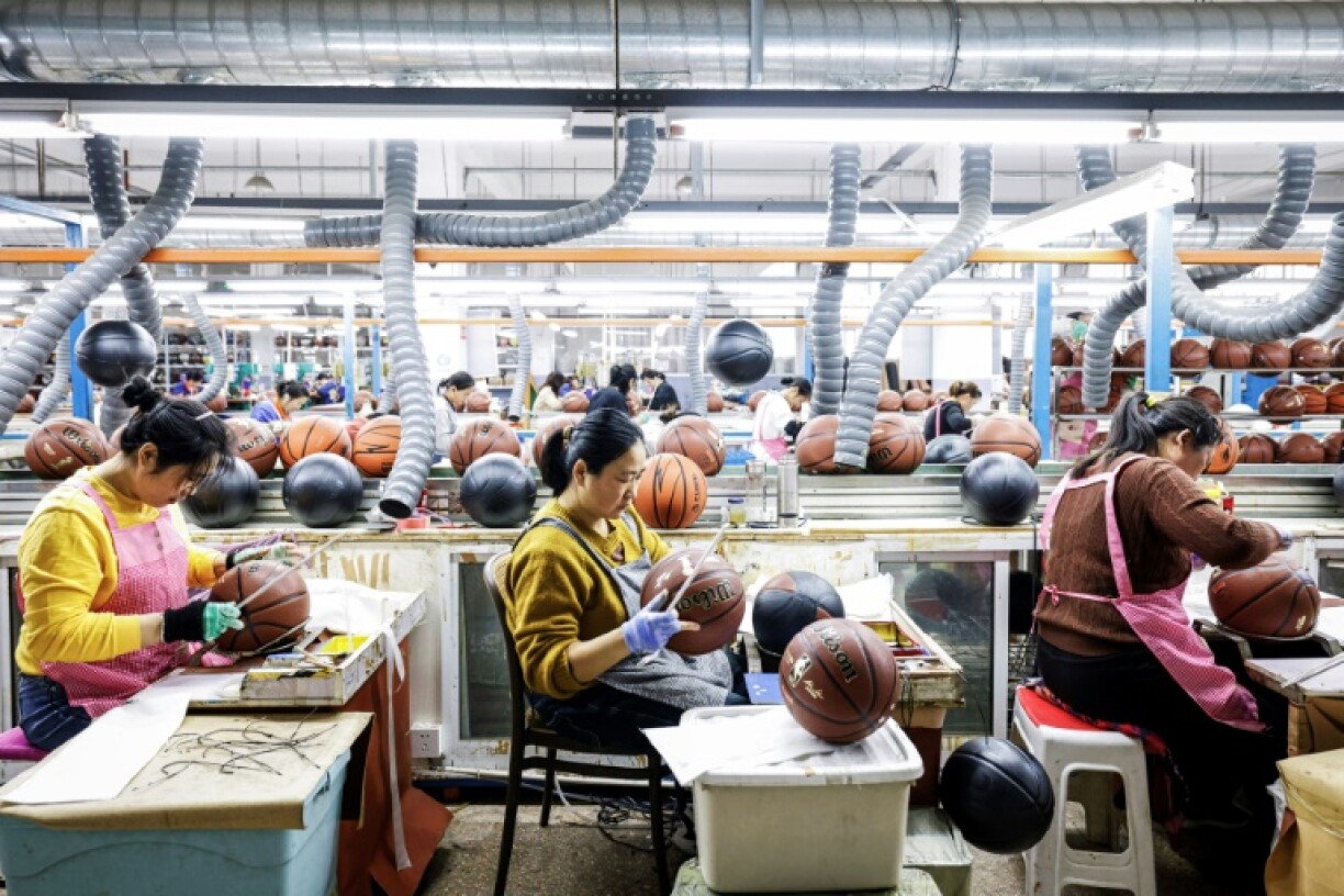 Employees produce basketballs that will be exported to Europe at a factory in Sihong, in eastern China's Jiangsu province on March 25, 2025.