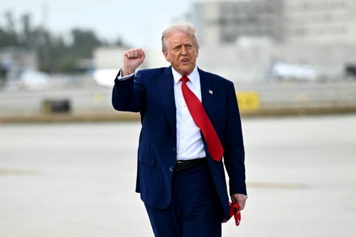 US President Donald Trump pumps his fist upon arrival at Miami International Airport