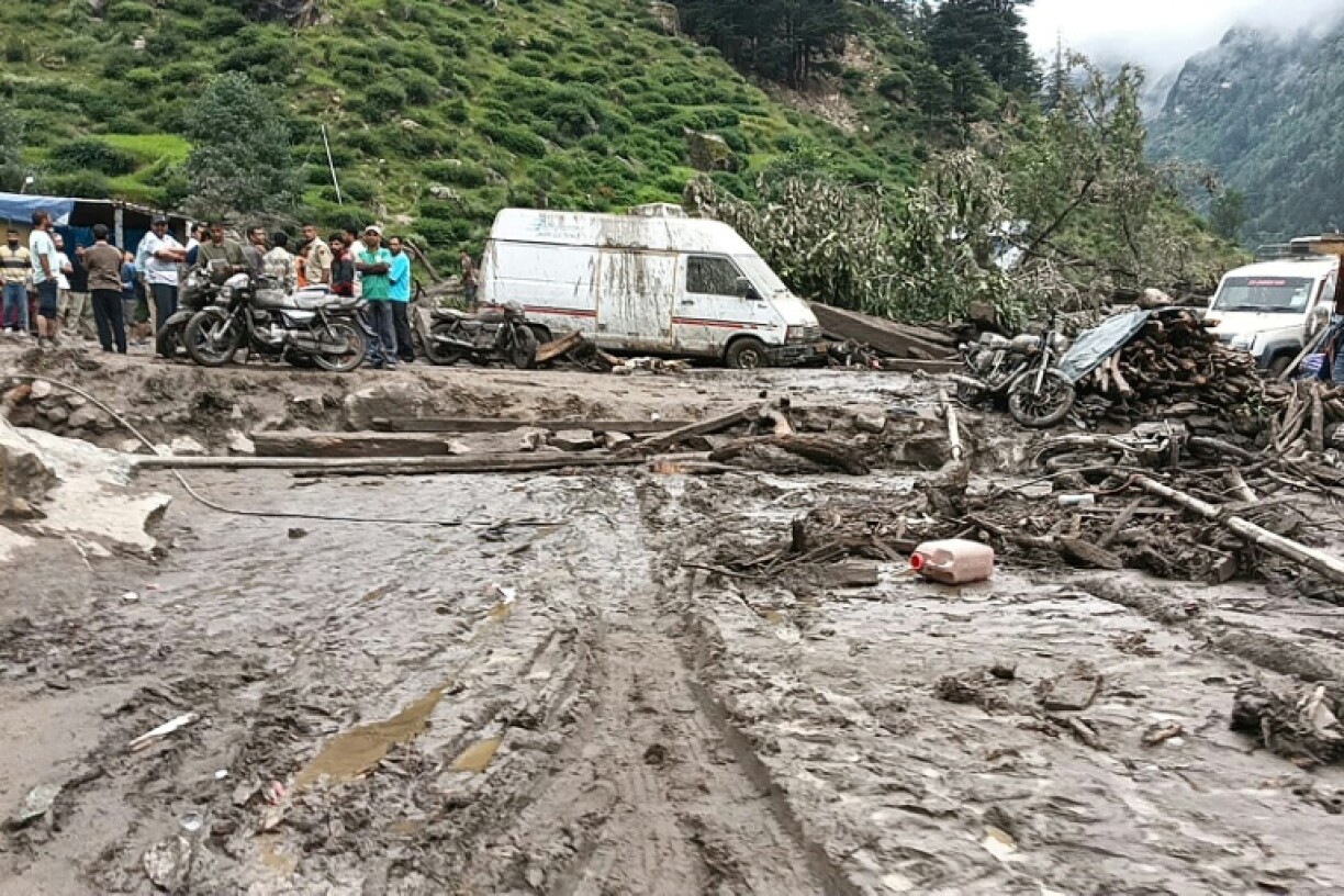 Rescuers inspect the site of a flash flood that has killed at least 60
