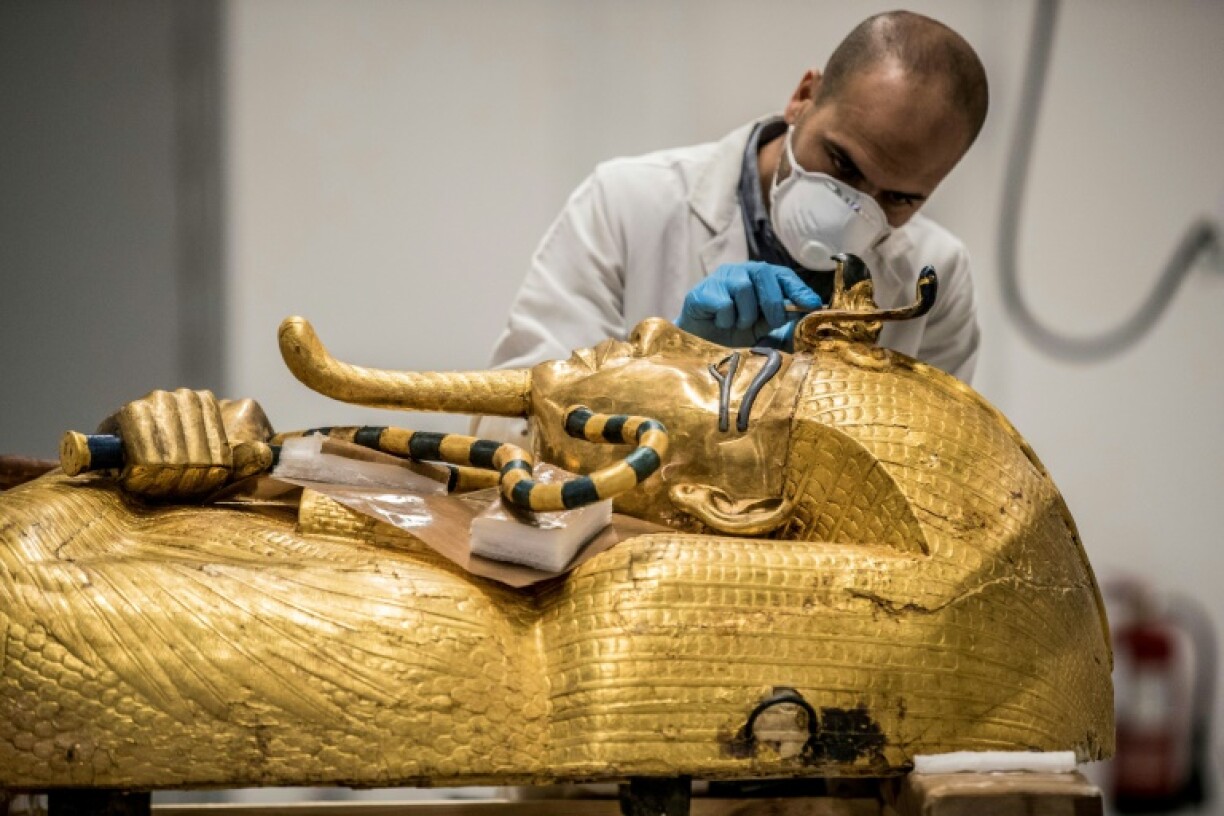 An archaeologist performs restorations on the sarcophagus of Pharaoh Tutankhamun in the restoration lab of the Grand Egyptian Museum in 2020