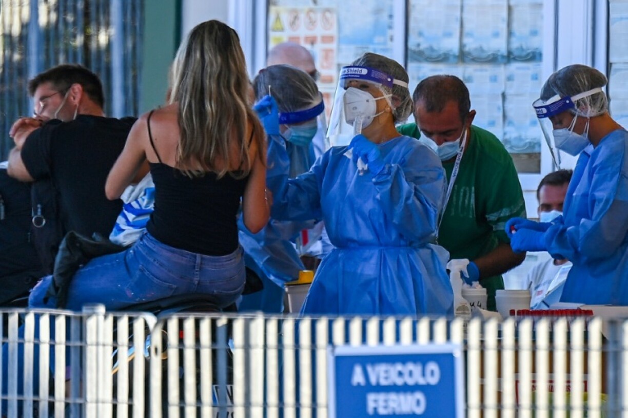 Des vacanciers à moto rentrant de Sardaigne en ferry sont testés pour le nouveau coronavirus au port de Civitavecchia, au nord-ouest de Rome, le 23 août 2020.