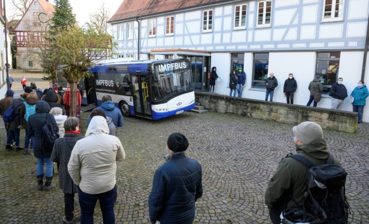 Des personnes attendent leur tour devant un bus de vaccination à Hemmingen, dans le sud de l'Allemagne, le 7 décembre 2021